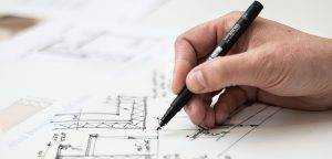 Hand with black pen drawing plans- Planning Permissions Sheds UK