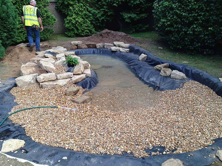 Filling a Garden Wildlife Pond with a hose.