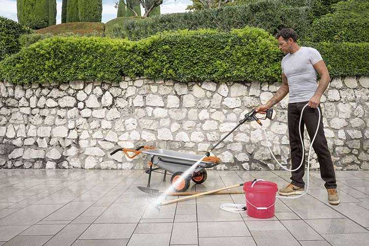 Cordless Jet Washers - man cleaning tiles outdoors with jet washer