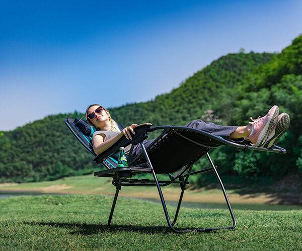 Zero Gravity Chairs - Lady outdoors lying in a zero gravity chair