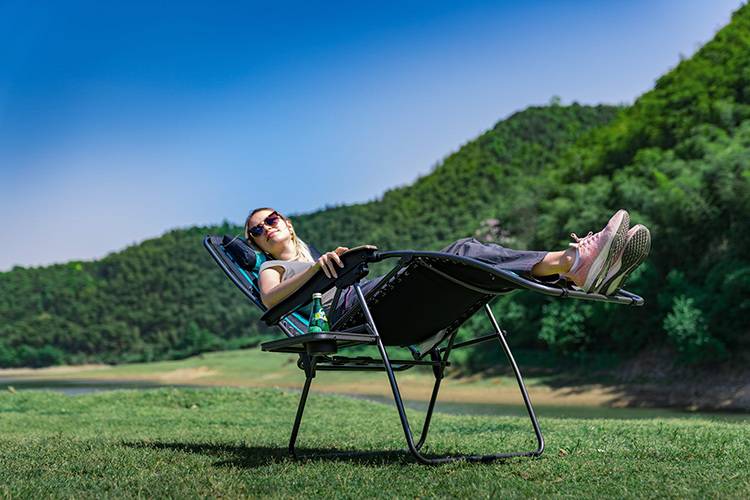 Zero Gravity Chairs - Lady outdoors lying in a zero gravity chair